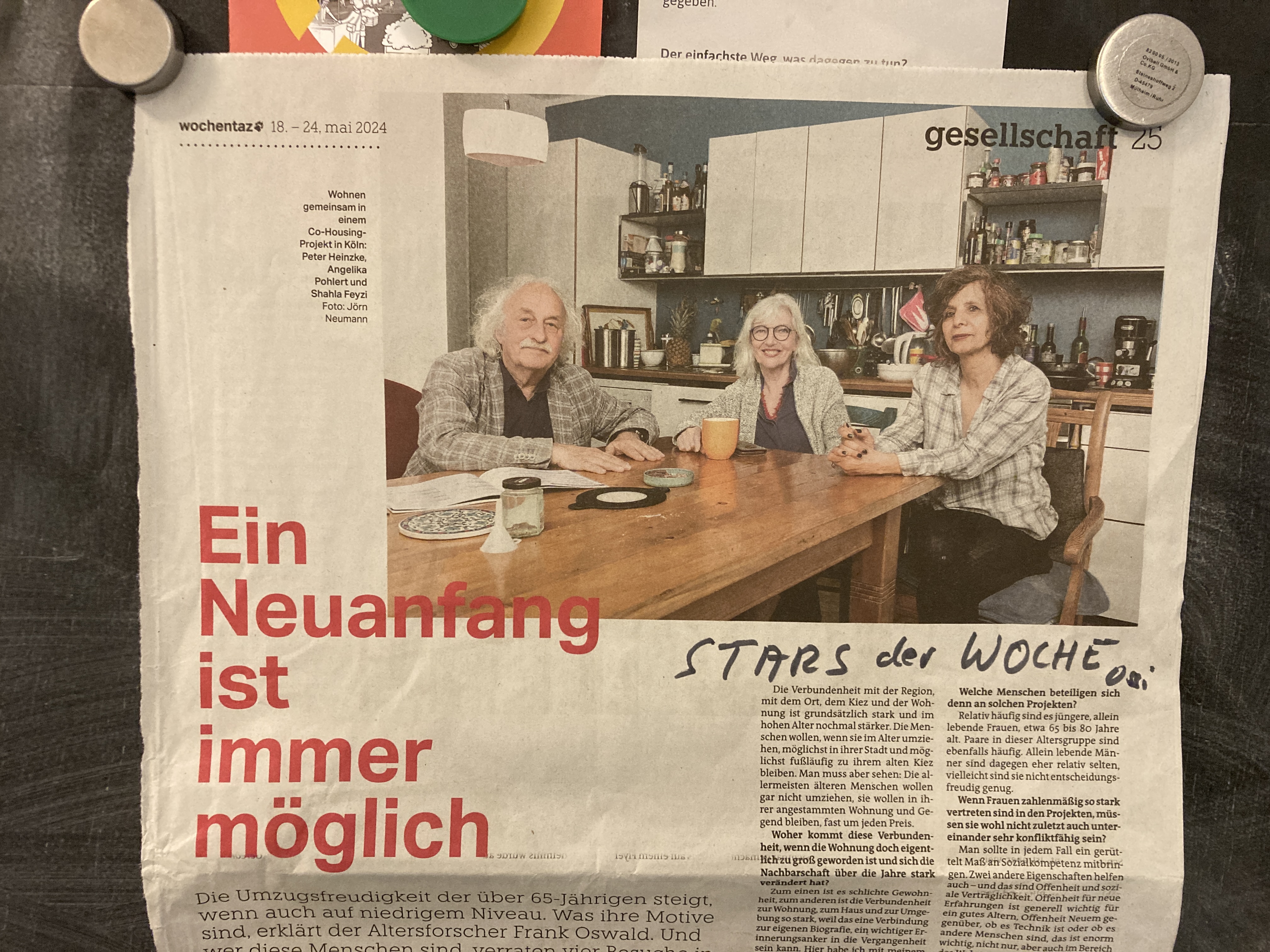 Foto eines Artikels in der TAZ mit der Überschrift "Ein Neuanfang ist immer möglich" und mit einem Foto von drei Personen, die an einem Küchentisch sitzen.